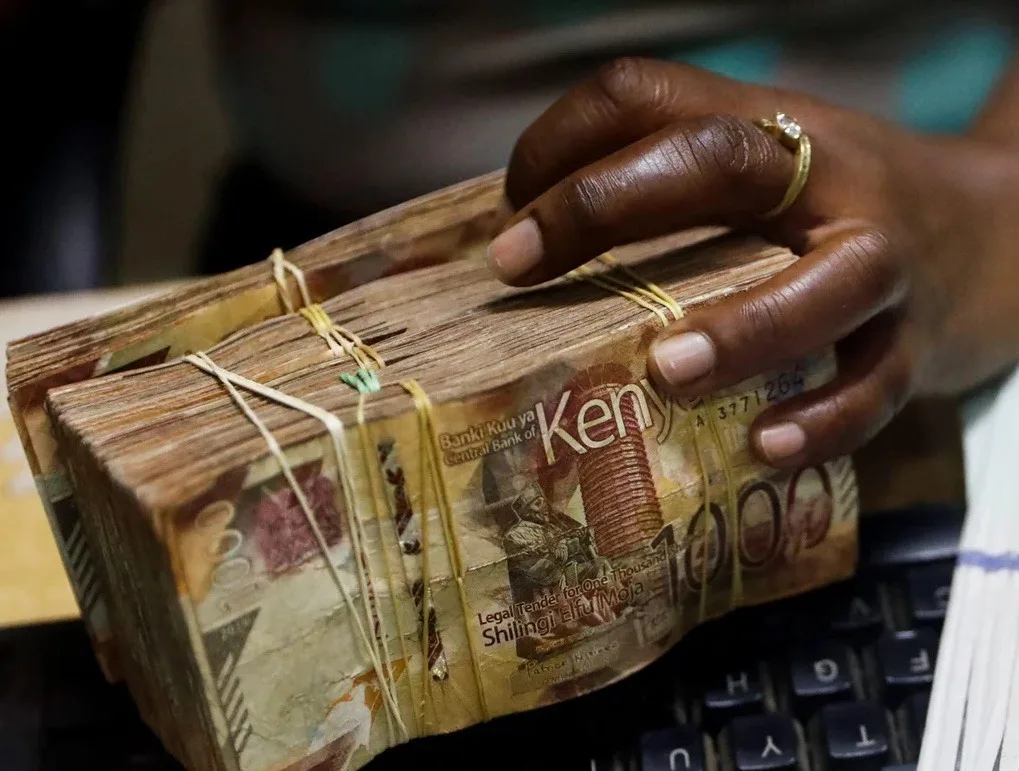 A hand holding bundles of Kenya Shillings 1000 notes representing Sh6 billion paid by public schools to KSSHA private association