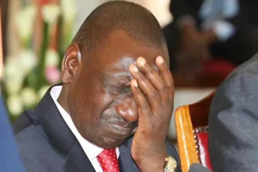 President William Ruto looking frustrated with hand on head - Auditor General report discredits Housing Levy and SHIF taxes